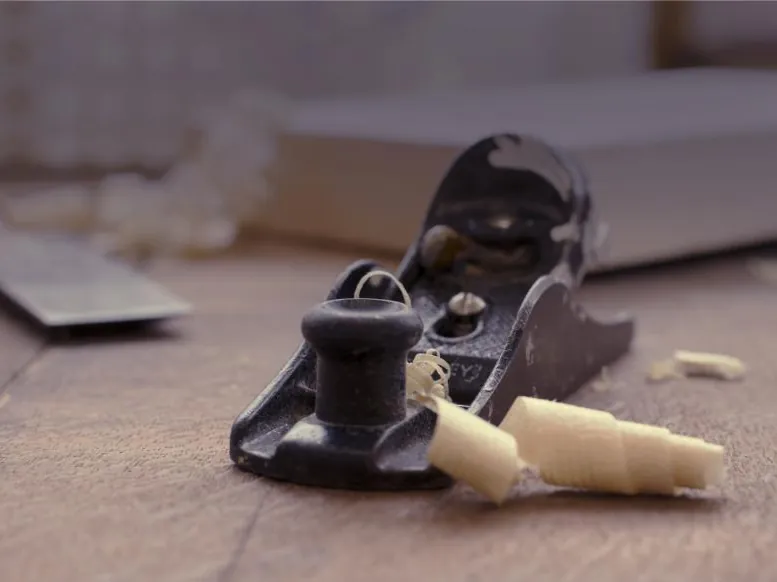 Sample photo: hand plane and wood shavings on a workbench.